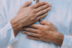 A man rests his open palms across his chest