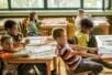 Children in school sit at their desks