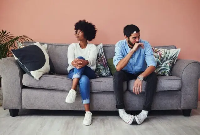 A couple on a couch faces away from each other