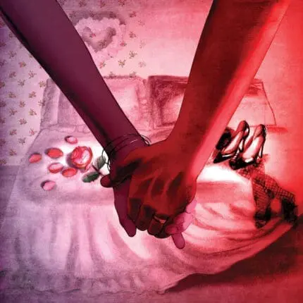 A couple holds hands in front of a bed