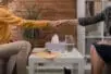 A therapist and client shake hands over a coffee table in the middle of the therapy room