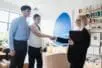 Photo of a young couple and their therapist with the young woman and the therapist shaking hands