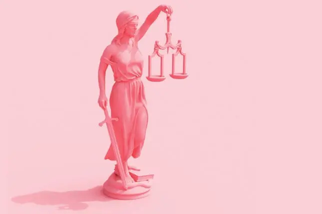 Lady justice holding scales and sword on pink background