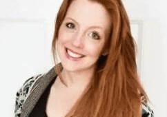 Red-haired woman in sweater smiling