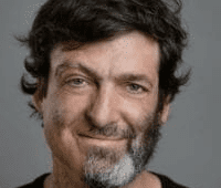 Man with a half beard smiling.