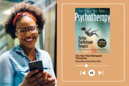 A woman looks at her phone happily while listening to her headphones