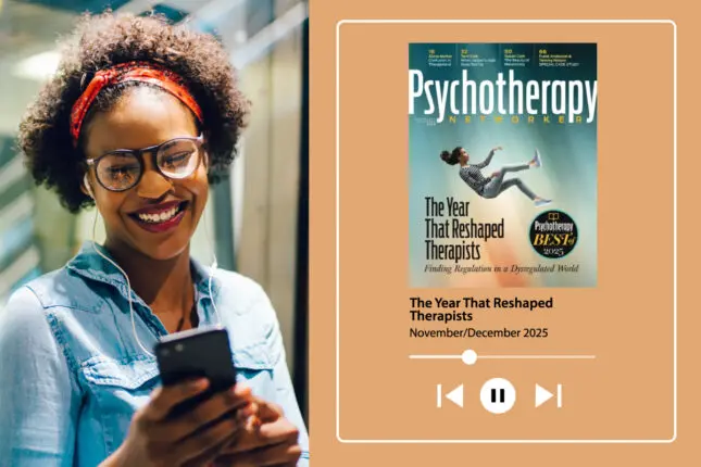 A woman looks at her phone happily while listening to her headphones