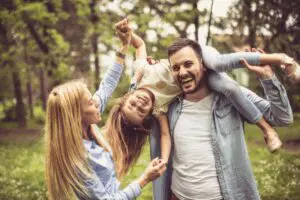 A mother, father, and daughter play together laughing