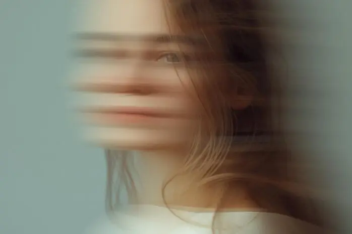 The blurred face of a woman turning to face the camera