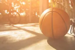 An abandoned basketball resting on the floor