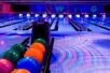 Photo of a bowling alley under dark and colorful lights