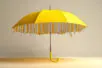 An open yellow umbrella shows an underside of sharp nails