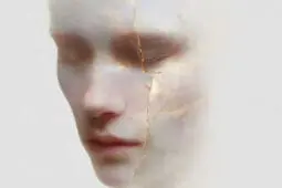A face with closed eyes made out of white marble