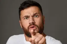 An angry man gestures toward the camera