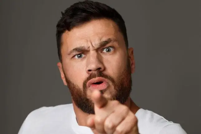 An angry man gestures toward the camera