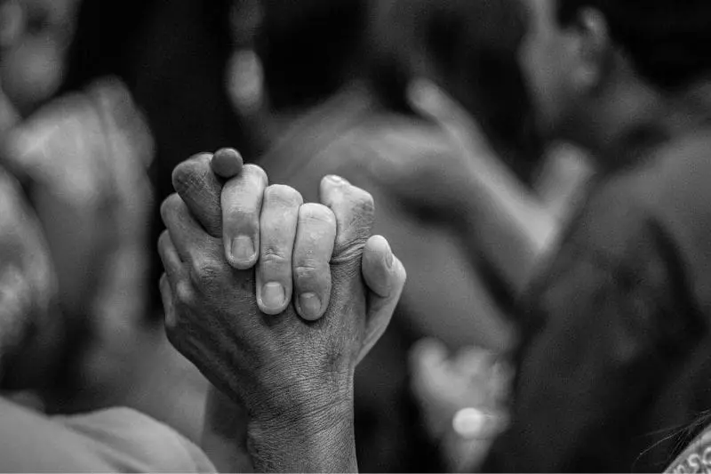 Image of two people's hands clasping together