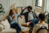 A couple sits on a couch during a therapy session talking intently