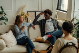 A couple sits on a couch during a therapy session talking intently