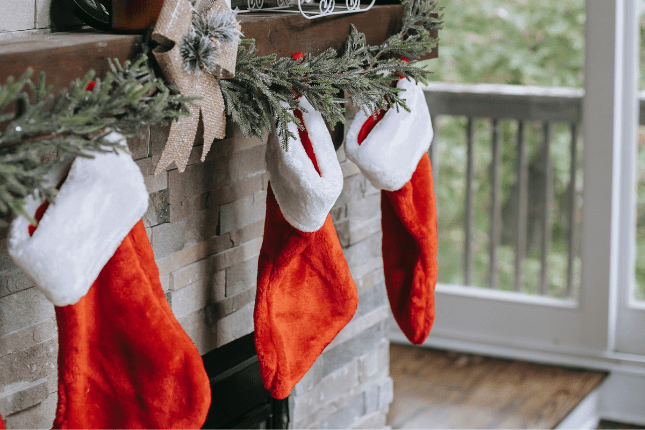 Holiday stockings on a mantle | Photo by Any Lane/Pexels