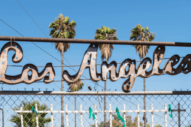 A metalwork sign that reads "Los Angeles" with palm trees in the background