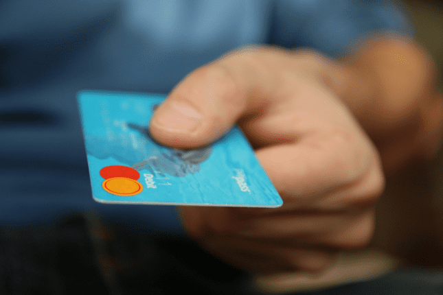 Man's hand holding a credit card | Photo by pixabay/Pexels