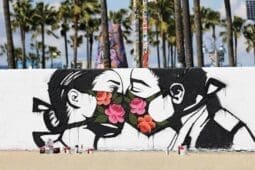 Graffiti of two masked people kissing