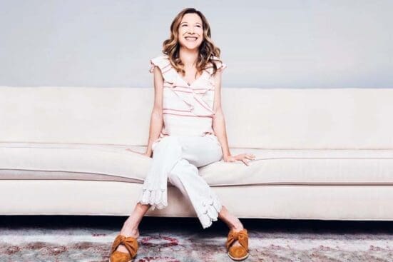 A smiling woman sitting on a couch