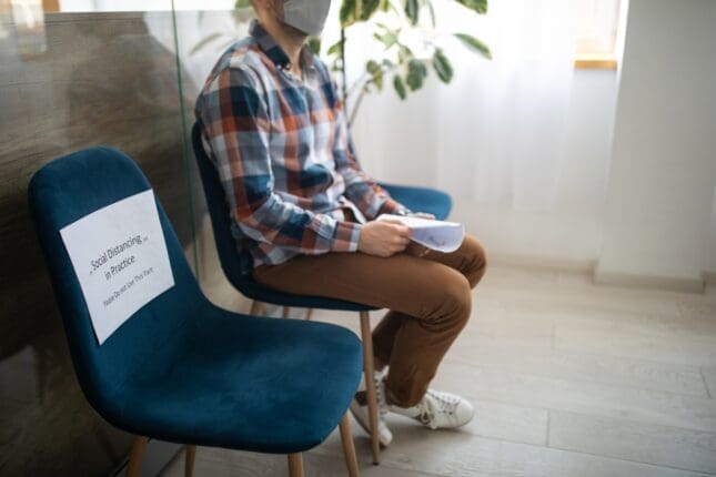 A man sitting a chair in a waiting room