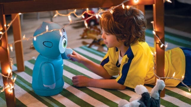 A boy interacting with a small blue robot