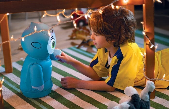 A boy interacting with a small blue robot