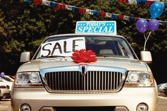 A car with a "for sale" sign on the windshield