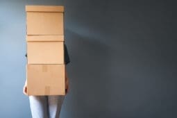 A person holds a stack of boxes