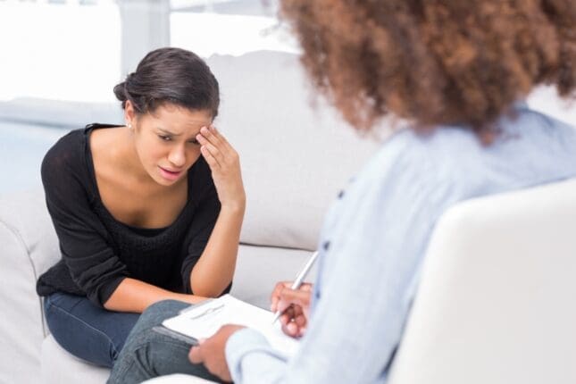 A young, distressed woman speaks to her therapist