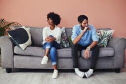 A couple on a couch faces away from each other