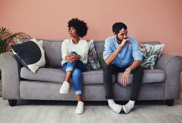 A couple on a couch faces away from each other