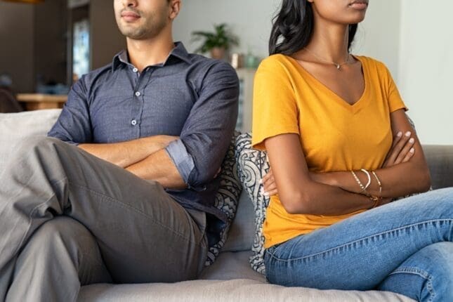 A couple with arms crossed faces away from each other