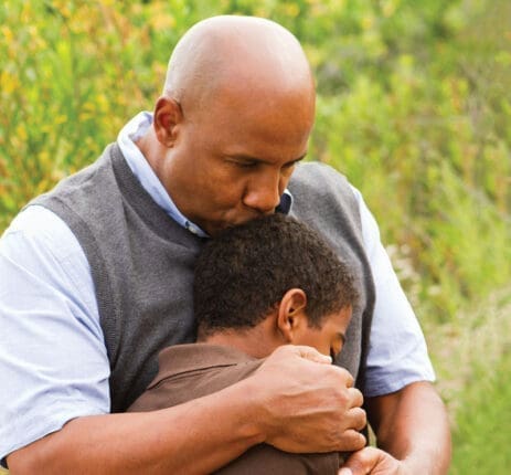 A father holds his son to his chest