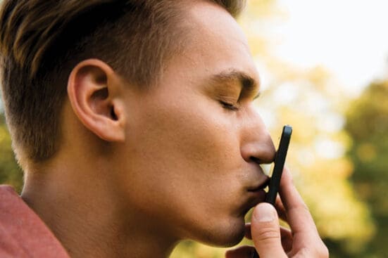 A man kisses his cell phone