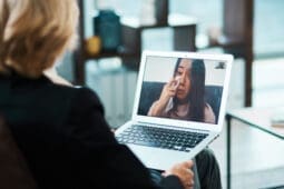 A woman cries onscreen as her therapist looks on