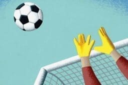 A goalie's hands reaching for a soccer ball