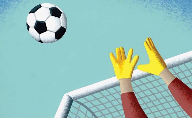 A goalie's hands reaching for a soccer ball