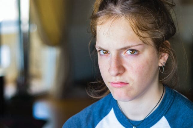 A teen girl angrily looks at the camera