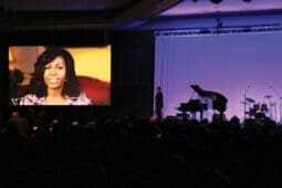 A woman's face projected on screen in front of an audience