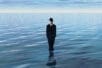 A man in a suit stands in a body of water