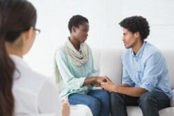 A couple on a couch in front of a therapist