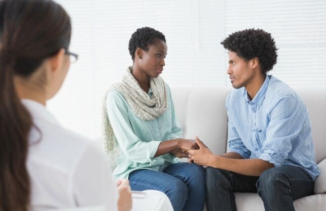 A couple on a couch in front of a therapist