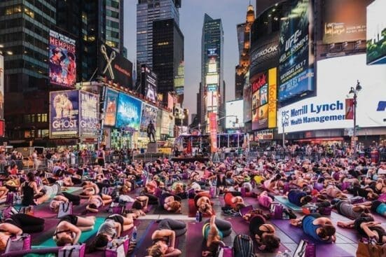 A crowd doing yoga in Times Square