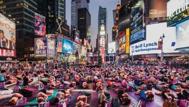 A crowd doing yoga in Times Square