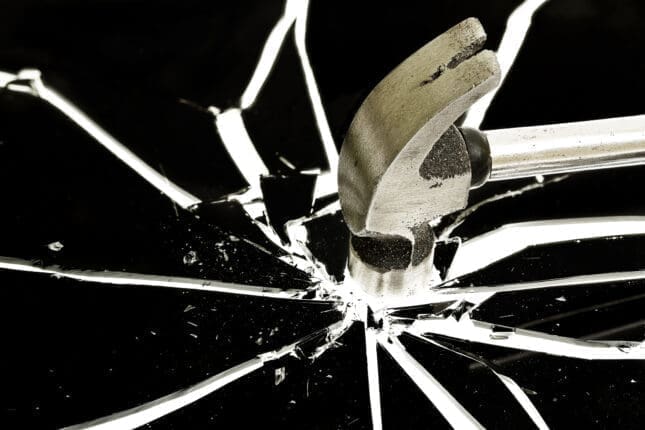 A hammer breaking glass