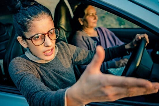 A woman in a car gestures with agitation